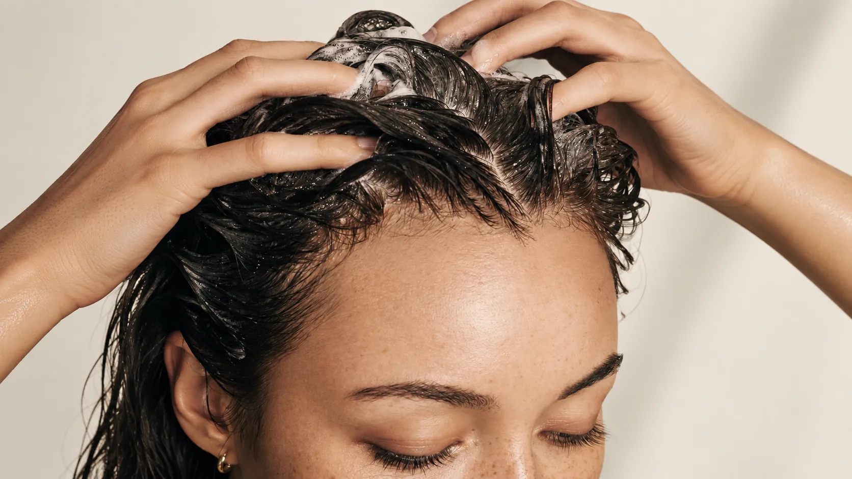 Close view of hair being washed at the scalp under running water