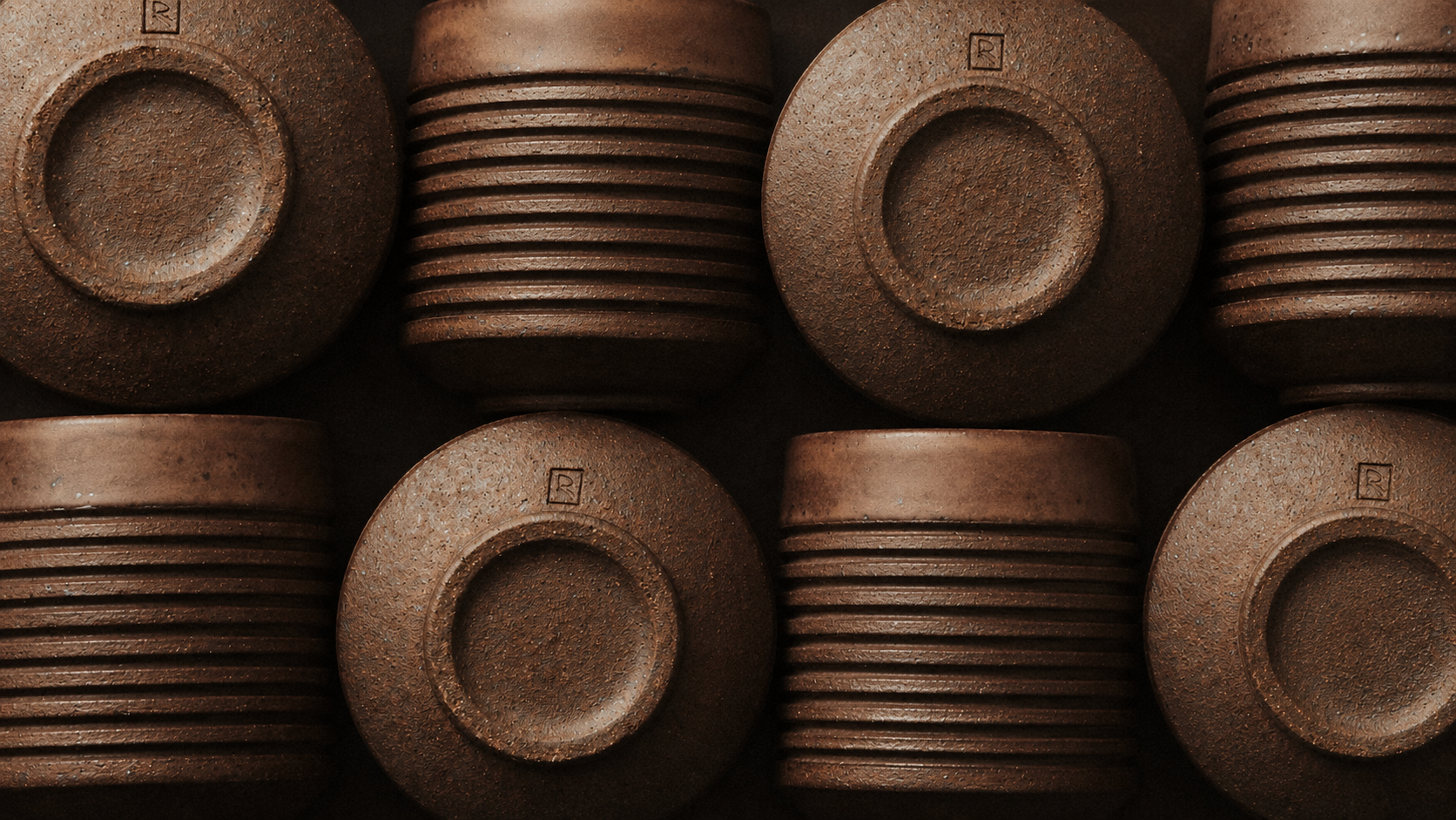 Hand-formed ceramic vessels with concentric ridges arranged in warm earth tones